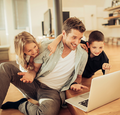 father and kids using a laptop