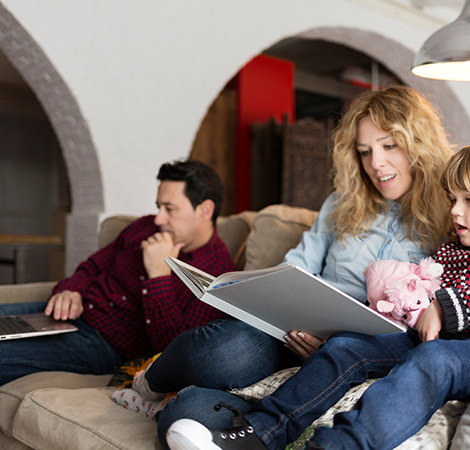 woman reading a book while a man looks at a website