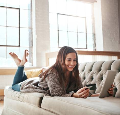 woman reading credit card on the couch