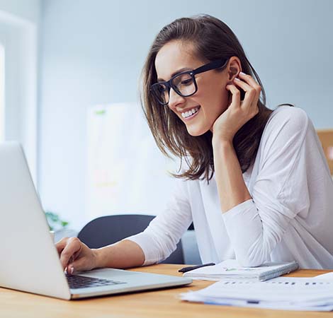 woman smiling and using laptop