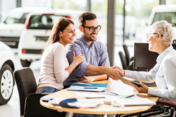 A couple completes their purchase of a car.