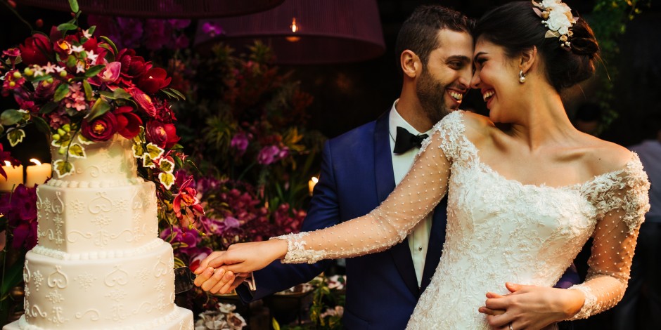 Newlyweds cut their wedding cake at an opulent celebration.