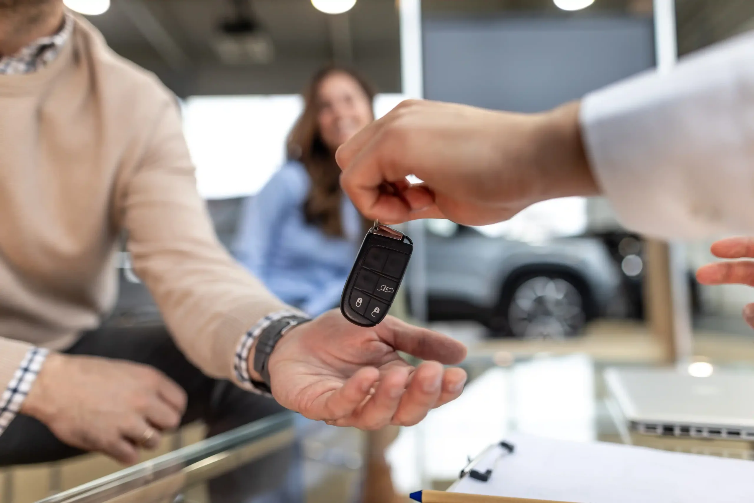 Salesman hands customer car keys
