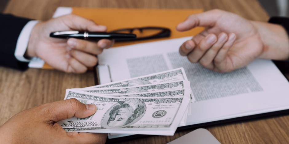 A borrower is about to sign for a stack of money.